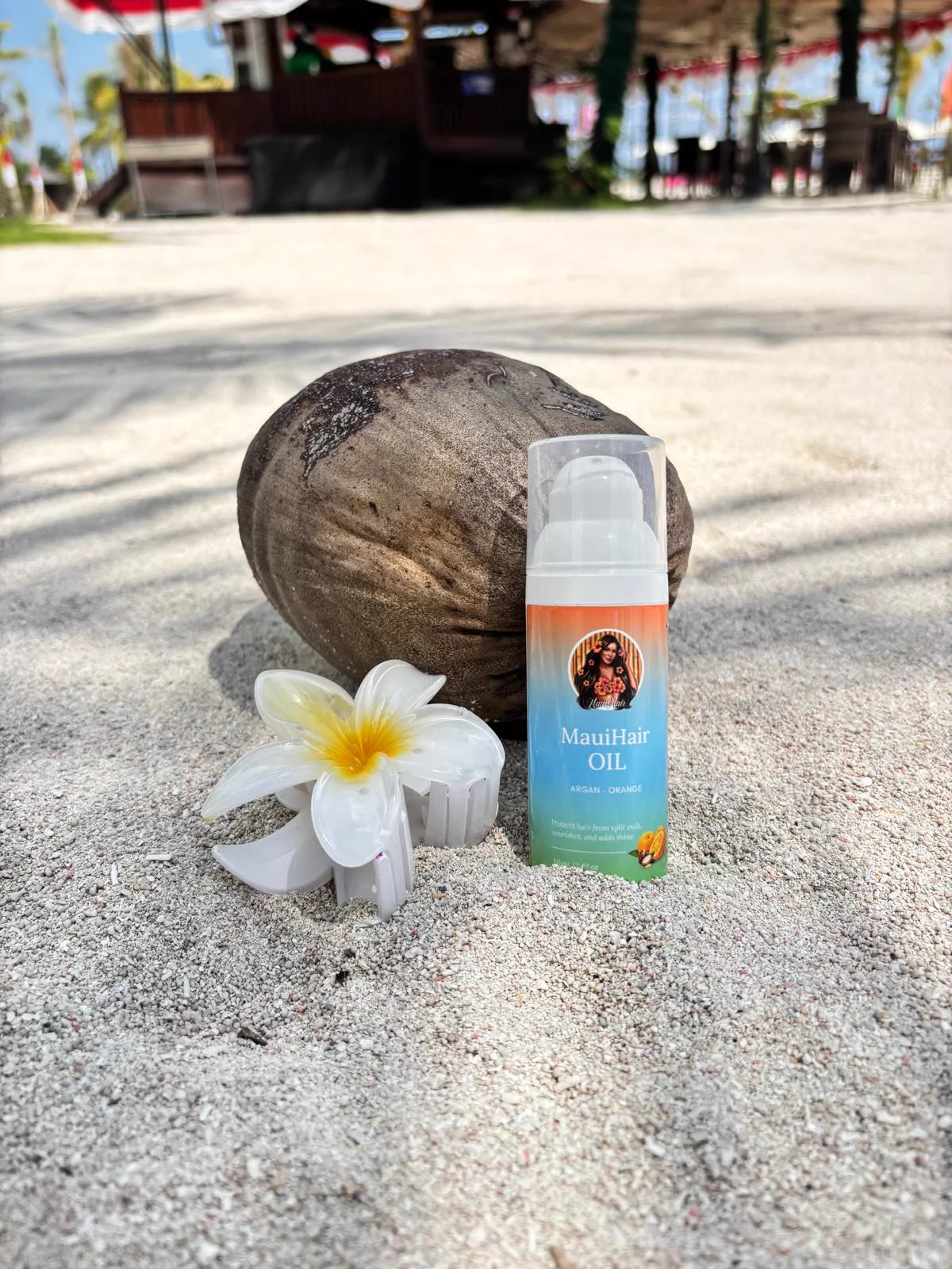 MauiHair olie met kokosnoot en bloem op het strand